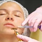 A cosmetologist injects a botulinum toxin to tighten and smooth out wrinkles on the skin of a female face.
