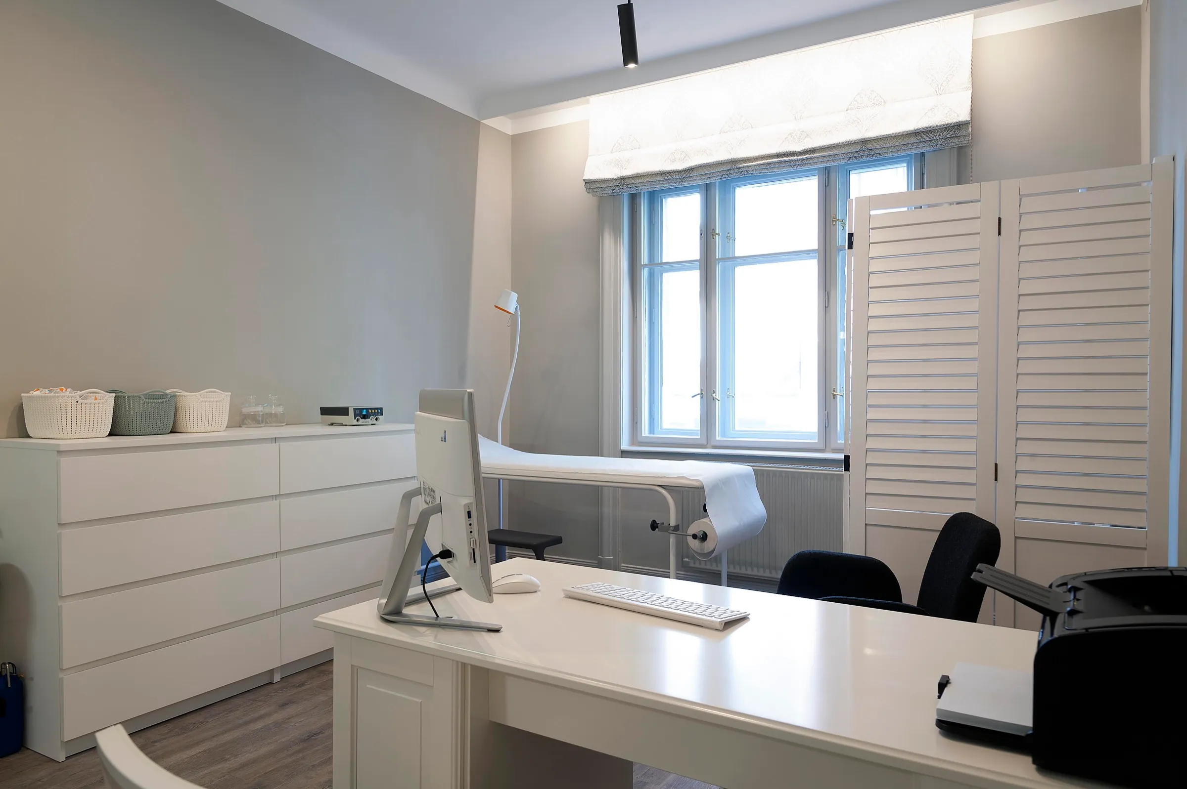 The consulting room with a desk and a large window