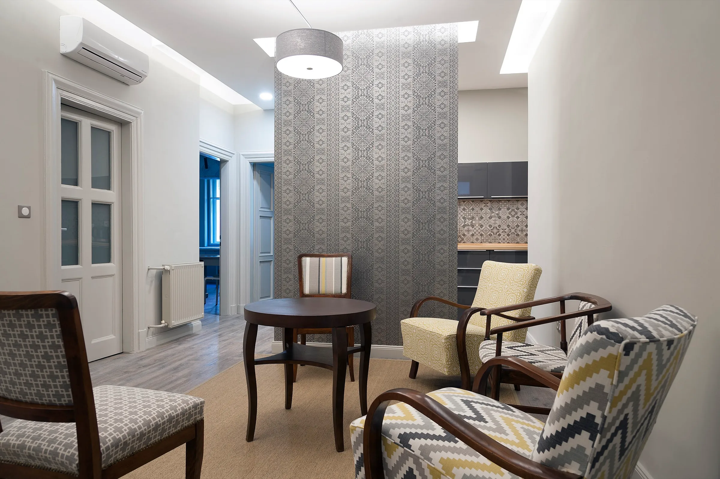 The waiting room with armchairs and patterned wallpaper